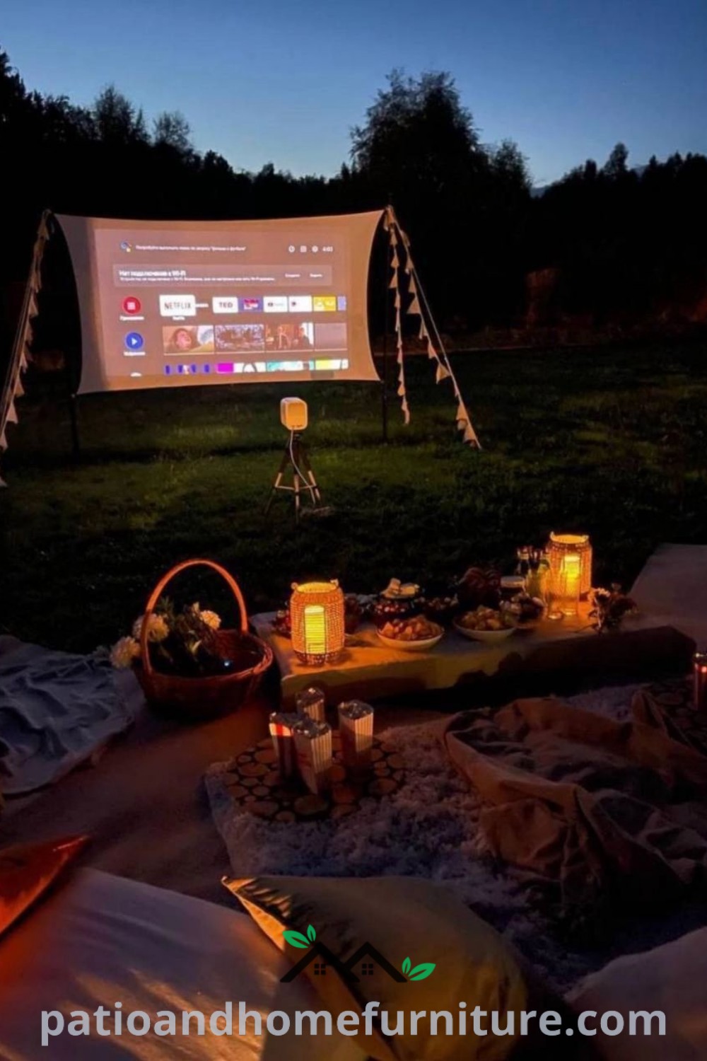 Cozy outdoor movie night setup on the grass with candles and a spread of food, creating an inviting atmosphere perfect for a romantic picnic or gathering, featured on wellnesswink.com.