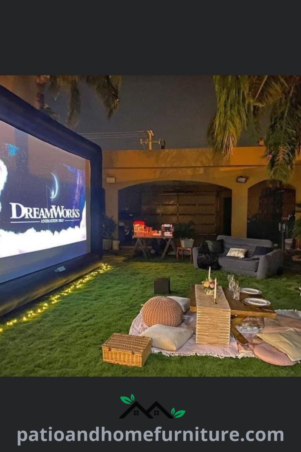Large screen TV on a lush green field in front of a building, perfect for a cozy outdoor movie night setup, offering inspiring backyard decor ideas with comfortable seating and whimsical lighting, featured on wellnesswink.com.