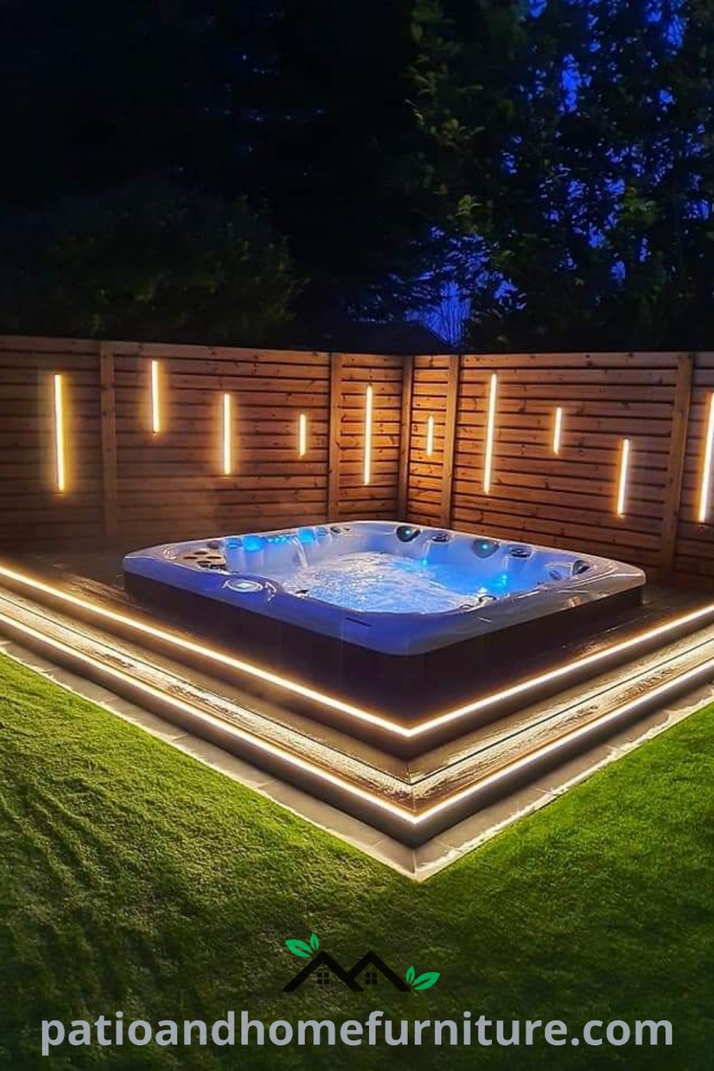 Outdoor hot tub lit at night in a garden, surrounded by decorative lights and grass, offering cozy decor ideas for creating a tranquil backyard retreat, as featured on wellnesswink.com.