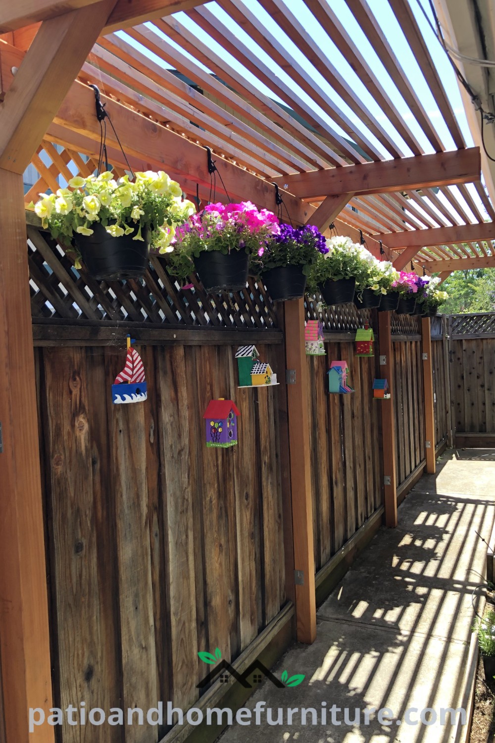 Wooden fence with potted plants hanging from its sides, creating a cozy and inviting outdoor space, showcasing unique decor ideas and inspirations for your home, as featured on wellnesswink.com.