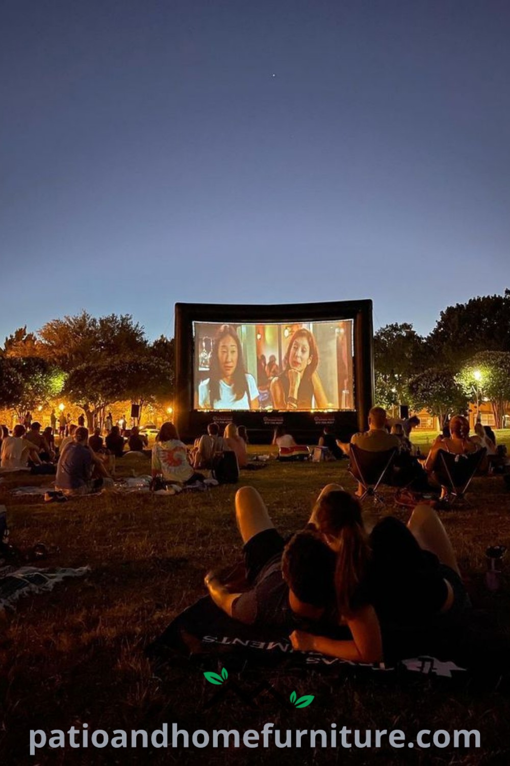 People sitting on the grass watching a movie on a large screen at night, surrounded by bright lights, creating a cozy outdoor cinema aesthetic, perfect for gatherings and movie nights at wellnesswink.com.