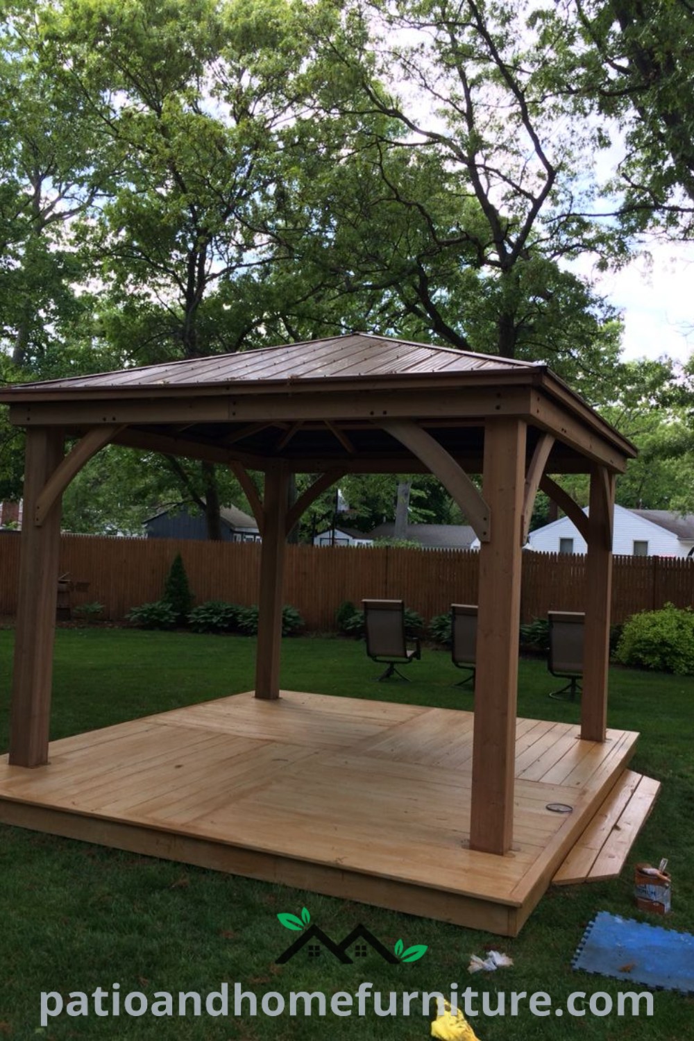 Wooden gazebo on a green field surrounded by flowers, showcasing cozy ideas for backyard decor and unique designs for outdoor living spaces on wellnesswink.com.