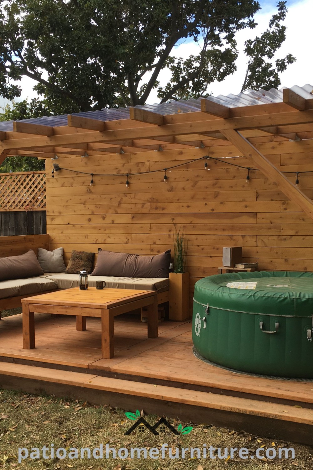 Backyard featuring a cozy hot tub surrounded by patio furniture and a privacy wall. The scene includes a charming shed, illustrating design ideas that inspire home relaxation and outdoor enjoyment, available at wellnesswink.com.