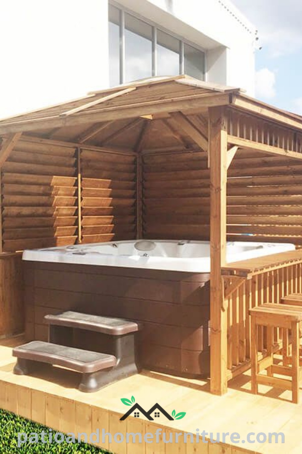 Hot tub sitting on a wooden deck next to a building and green grass, showcasing cozy ideas for creating a relaxing backyard oasis, featuring unique decor inspirations and practical design ideas for your home, wellnesswink.com.