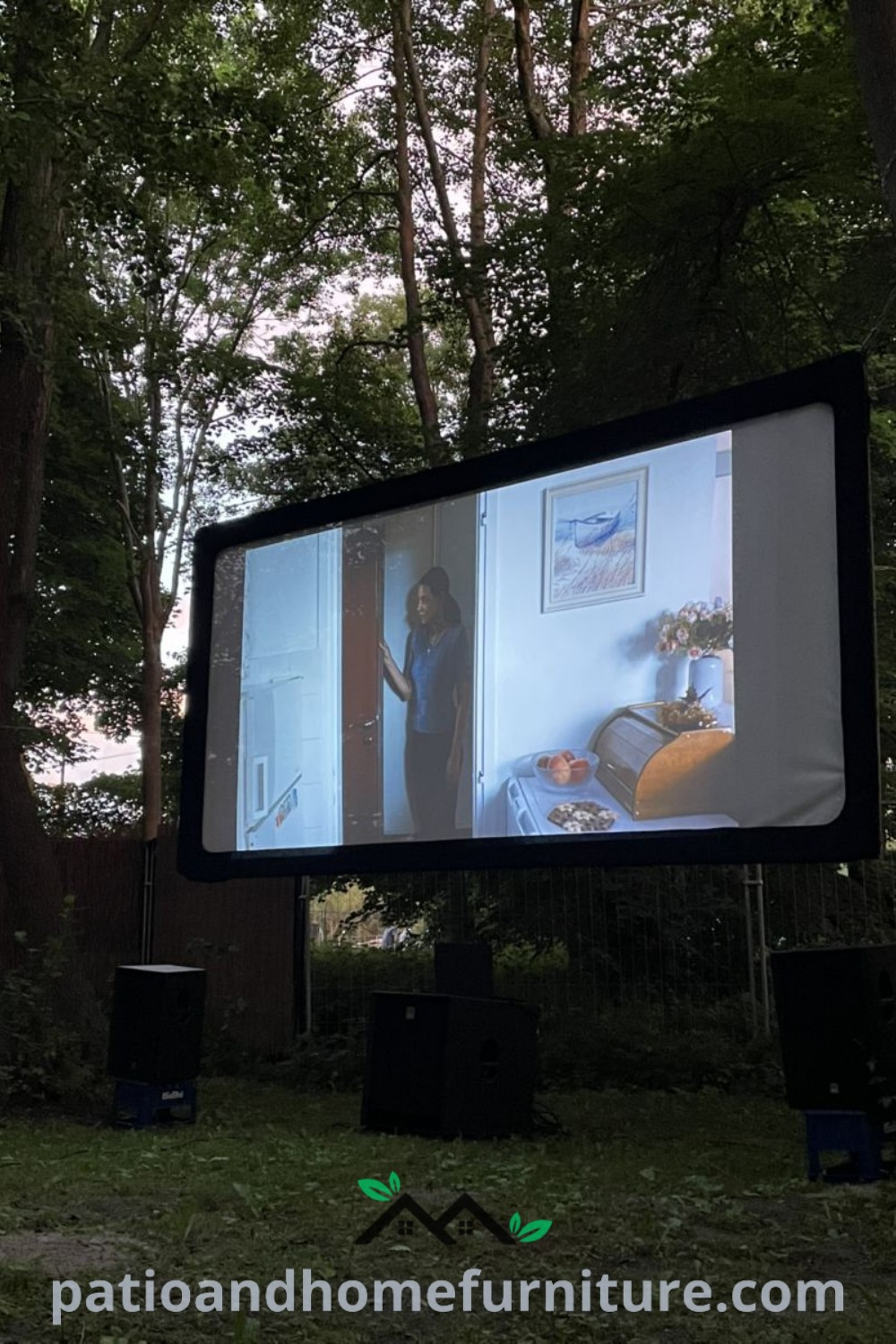 Woman enjoying an outdoor movie screening in a tree-covered field, with a large screen in the background and a food truck nearby, combining cozy vibes and a unique experience for a perfect night under the stars at wellnesswink.com.