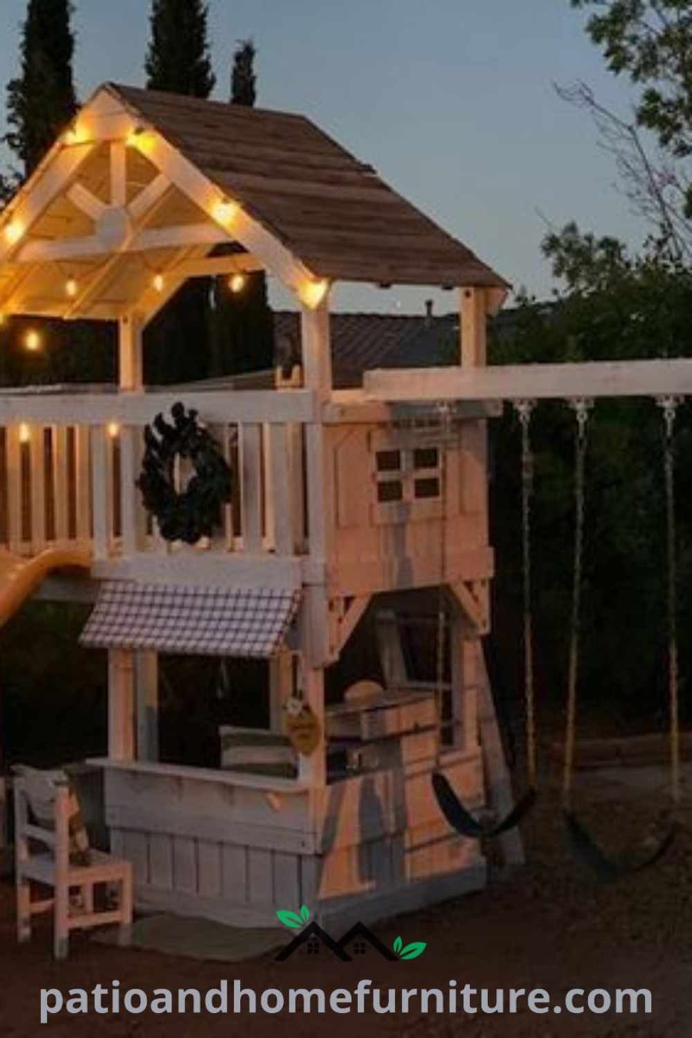 Wooden swing set with lights, featuring a slide next to it in an inviting evening setting, representing cozy backyard design ideas from wellnesswink.com.