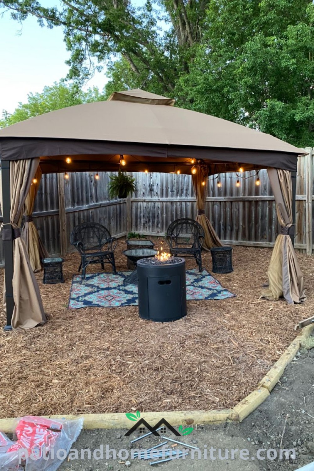 Backyard featuring a cozy fire pit, patio furniture, and a soft-top gazebo, providing unique decor ideas and inspirations for creating a charming outdoor oasis, as showcased on wellnesswink.com.