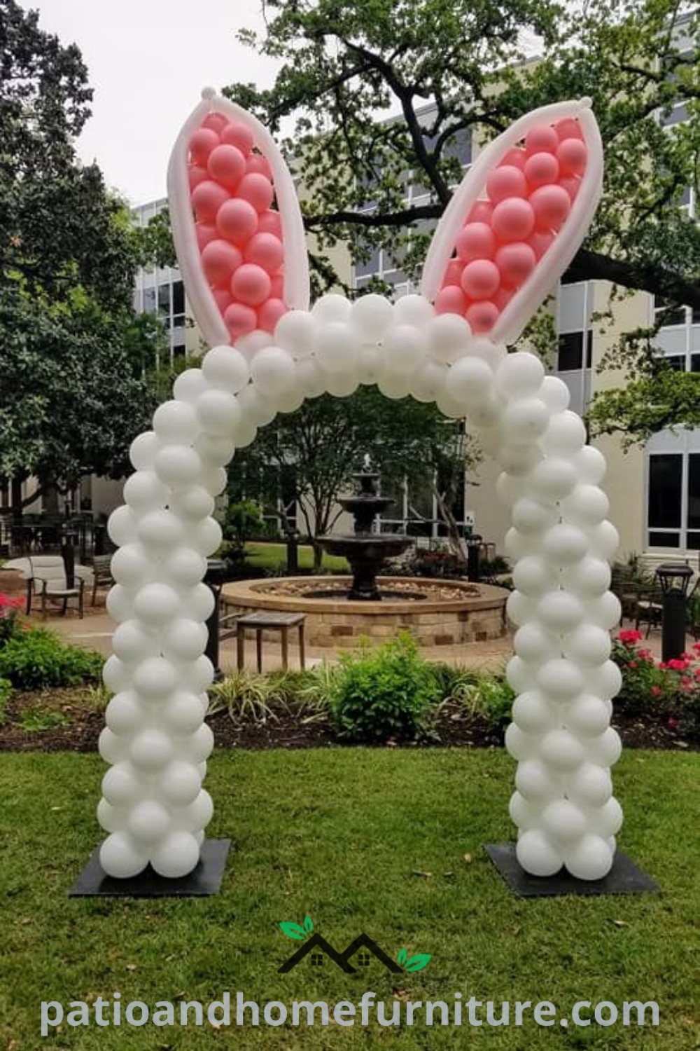 Inflatable bunny ears arch with pink and white balloons on a front lawn, creating a festive atmosphere for Easter celebrations. Discover cozy ideas for outdoor party decorations at wellnesswink.com.
