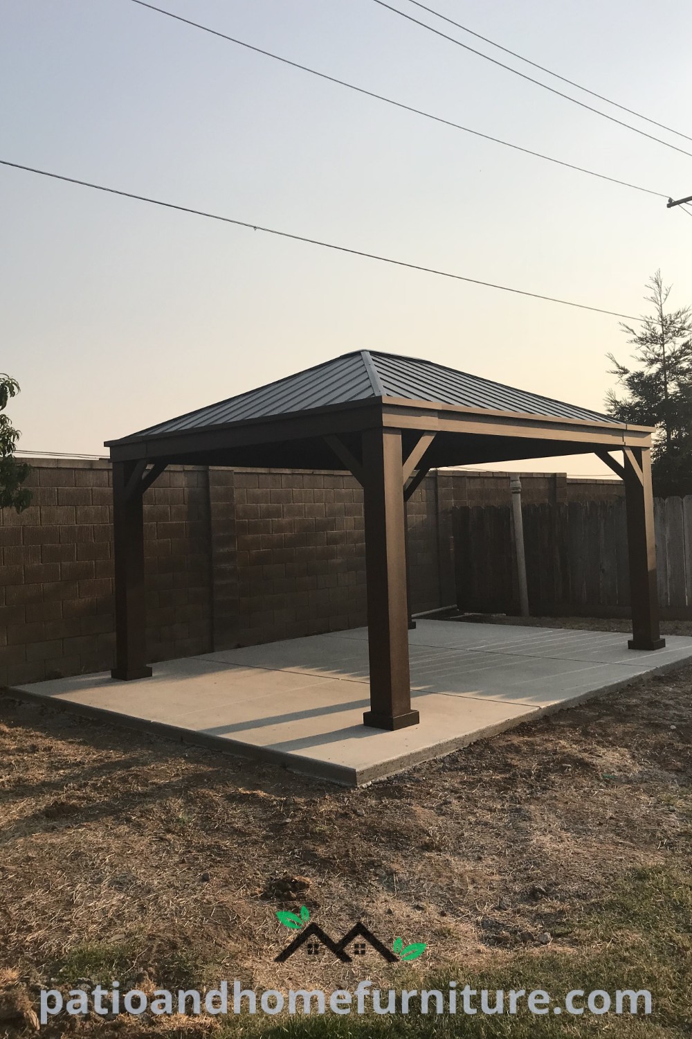 Wooden gazebo in a lush yard beside a brick wall, showcasing cozy design ideas and decor inspirations for an inviting outdoor space for relaxation or entertaining, featured on wellnesswink.com.