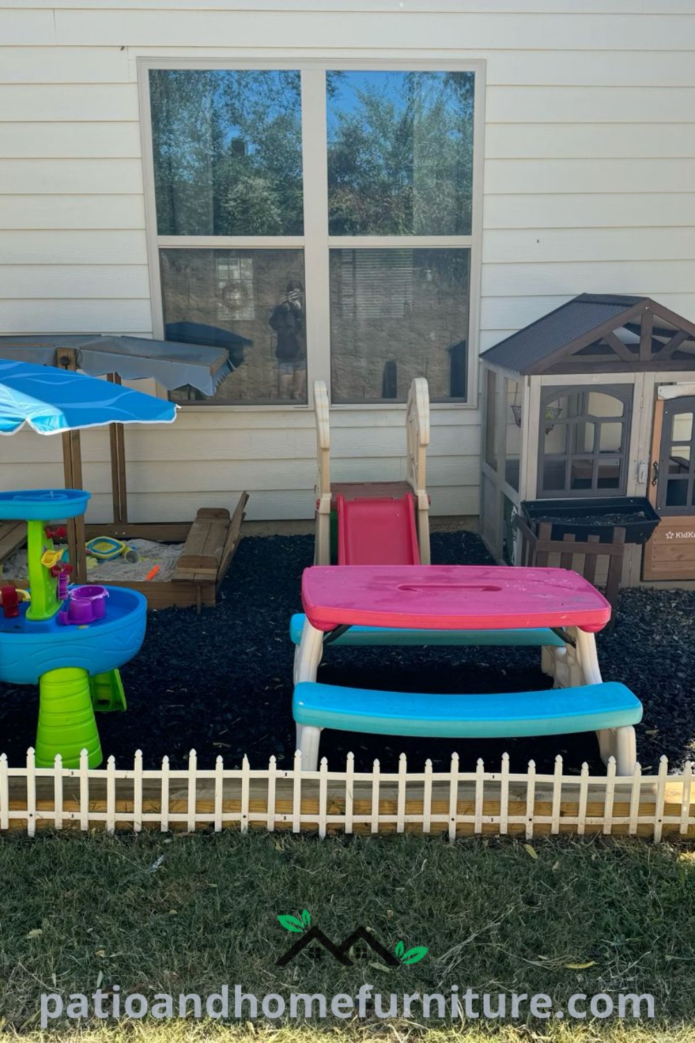 Charming outdoor play area with chairs and umbrellas in front of a house, including a doghouse, showcasing cozy home design ideas and inspiring outdoor decor ideas for family fun at wellnesswink.com.