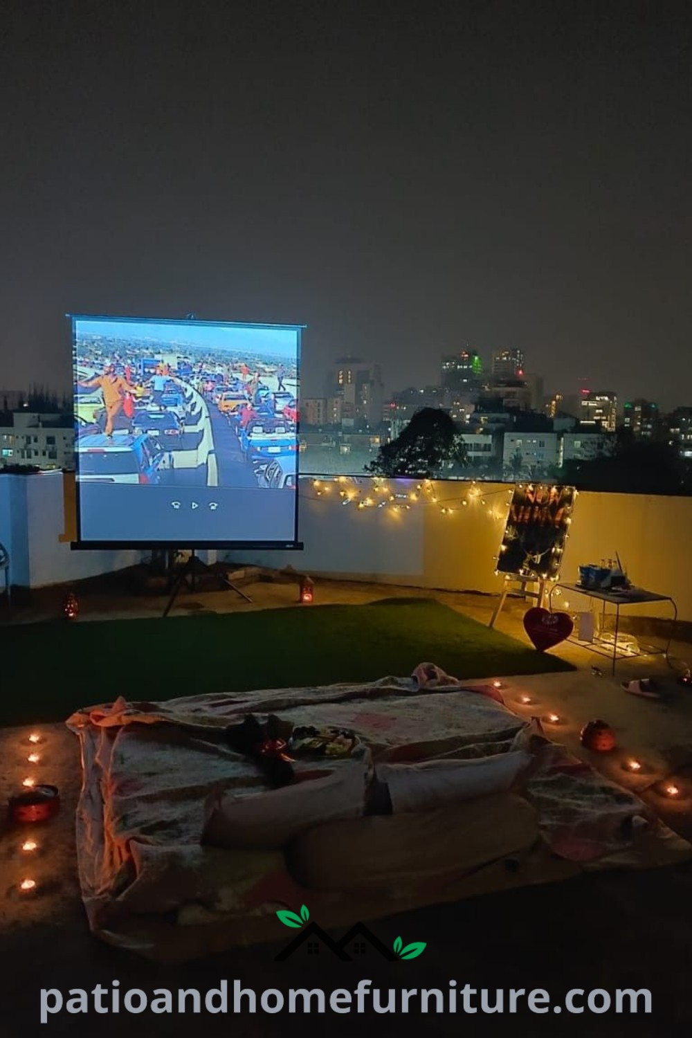 Rooftop movie night setup featuring a large screen, lit candles, and cozy seating for a charming outdoor cinema experience, showcasing inspiring decor ideas at wellnesswink.com.