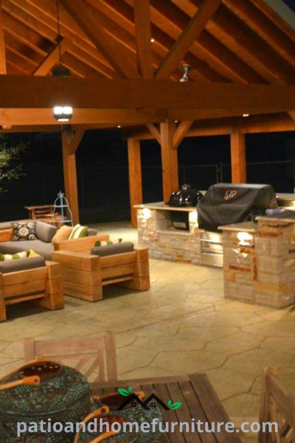 Cozy outdoor kitchen and dining area with wood beams, pizza oven, and ambient lighting, creating an inviting space for gatherings at night, showcasing decor ideas and design inspirations for your home on wellnesswink.com.