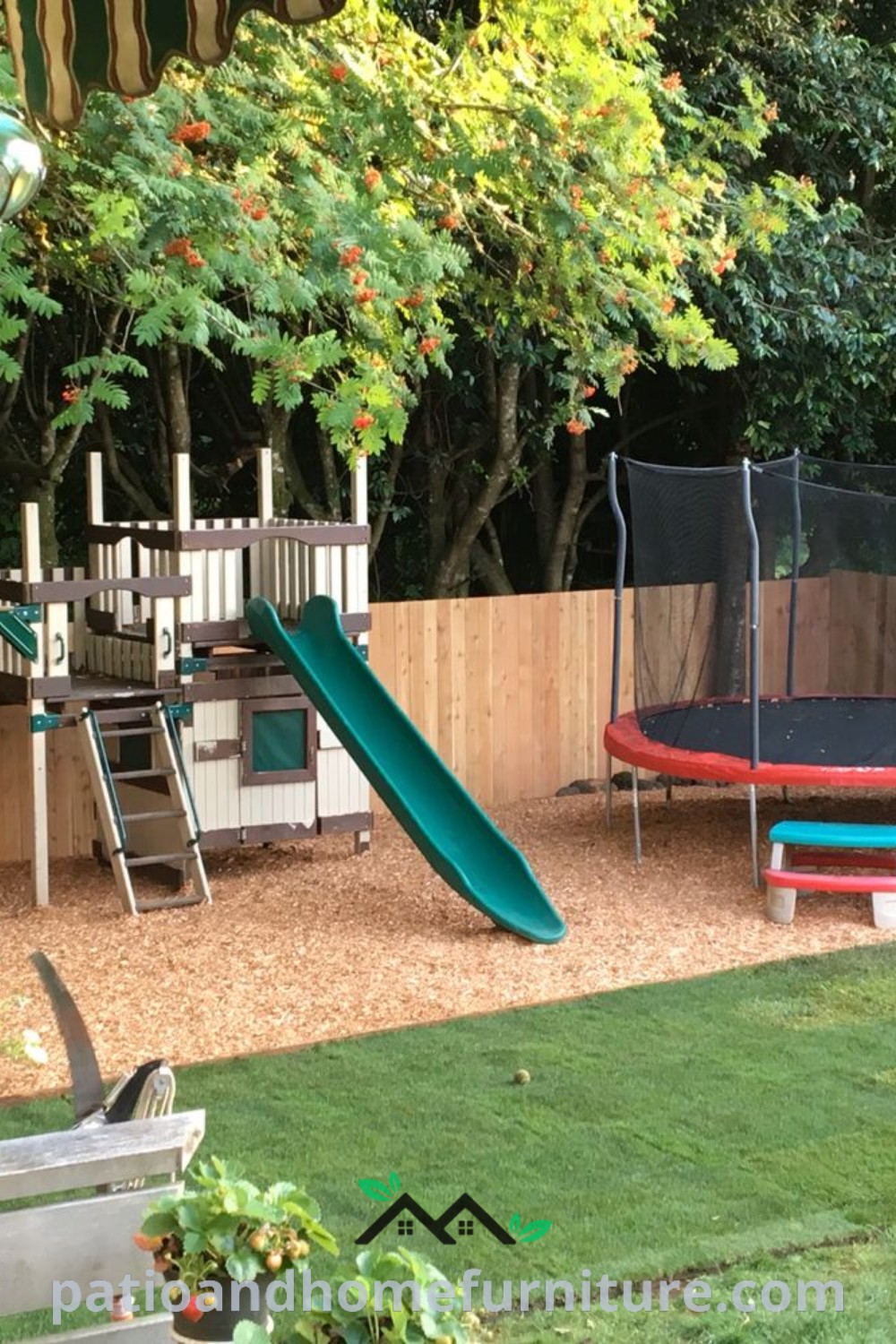 Bright and cheerful backyard kids play area with a trampoline, slide, and flower pots, showcasing unique design ideas for outdoor fun and relaxation at wellnesswink.com.