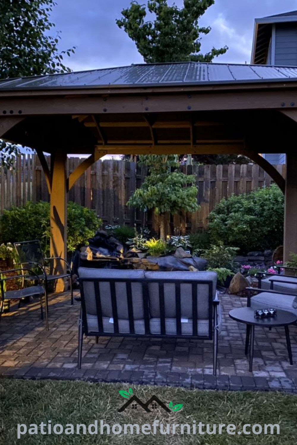 Cozy outdoor patio setup featuring comfortable chairs, a stylish table, and twinkling lights, showcasing unique design ideas for home backyard decor from wellnesswink.com.