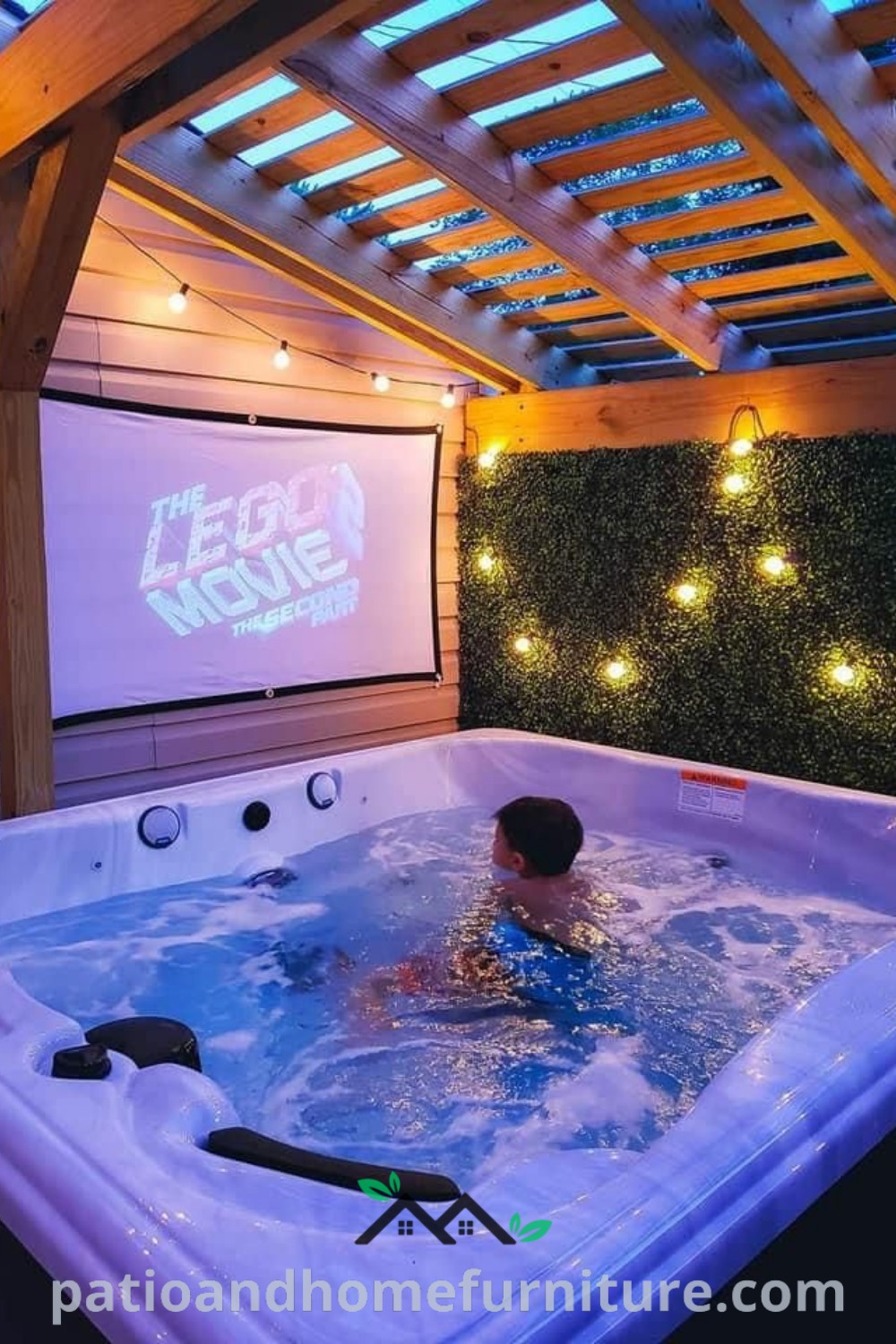 A man in a hot tub watching a movie on a projector screen in a winter gazebo setting, showcasing cozy decor ideas and backyard inspirations for relaxation, featured on wellnesswink.com.