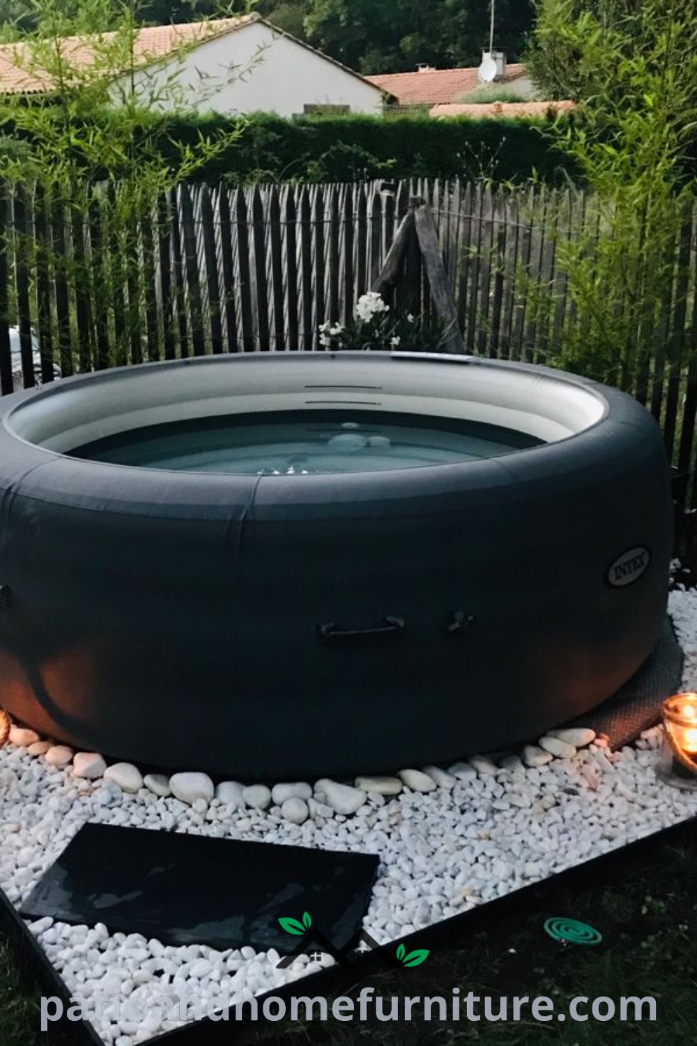 Inflatable hot tub surrounded by gravel and candles, creating a cozy outdoor oasis perfect for relaxation and gatherings. Inspiring decor ideas for a serene backyard experience at wellnesswink.com.