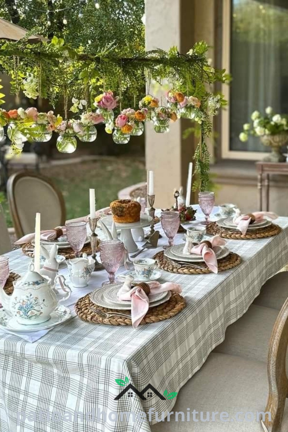 A charming outdoor table set for a tea party with hanging flowers from the ceiling and elegant plates arranged, offering cozy ideas for unique outdoor decor inspirations on wellnesswink.com.