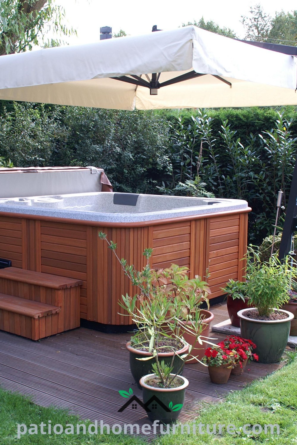 Outdoor hot tub surrounded by potted plants and trees, featuring an umbrella overhead for shade, illustrating cozy ideas for a beautiful backyard retreat, as seen on wellnesswink.com.