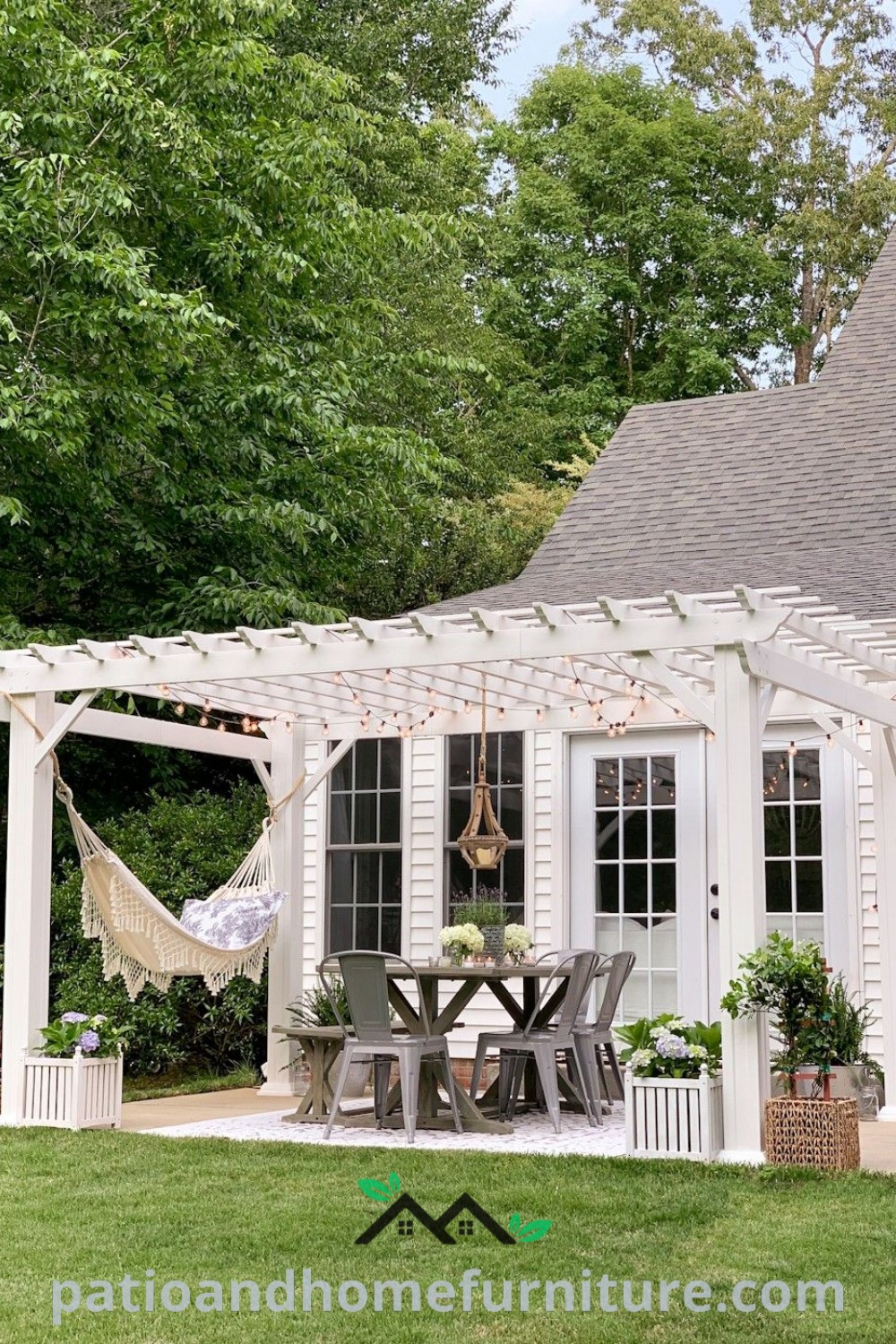 Cozy outdoor space with a white house, hammock, and stylish dining area under a pergola, offering unique decor ideas for creating a serene home environment, showcasing wellnesswink.com.