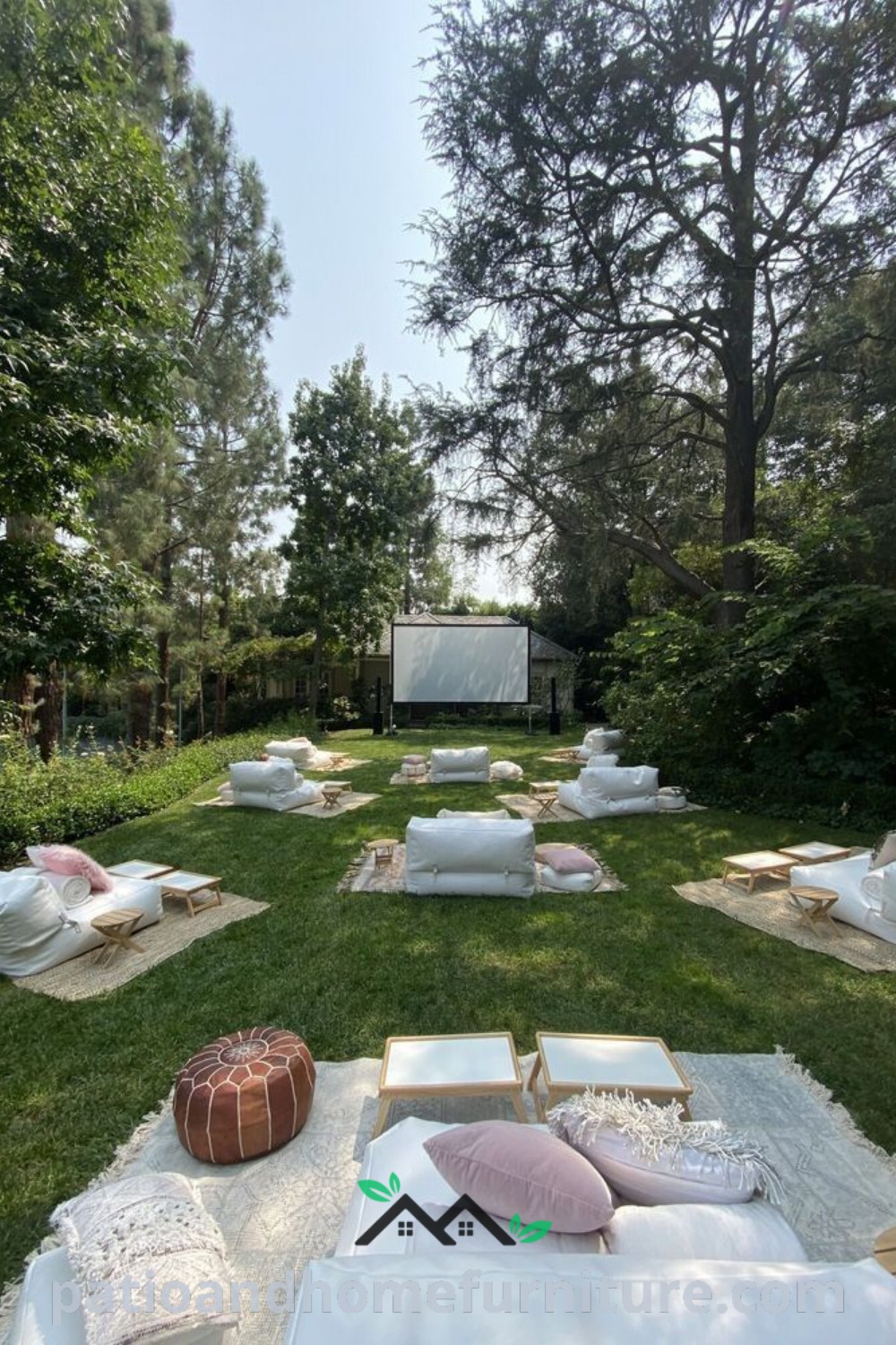 Outdoor movie setup in a grassy area featuring colorful pillows and cushions, creating a cozy atmosphere for a nighttime film experience, complemented by fairy lights and ideal for backyard gatherings, inspired by wellnesswink.com.