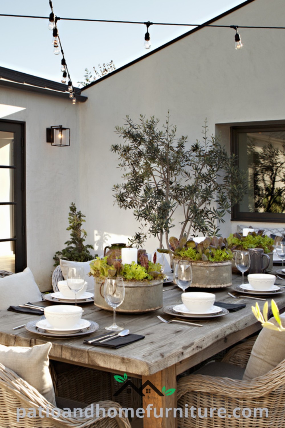 Outdoor dining area with wicker chairs and wooden table set for four, surrounded by potted trees, showcasing cozy design ideas for a modern cottage backyard, www.wellnesswink.com.